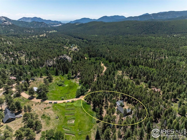 birds eye view of property featuring a mountain view and a wooded view