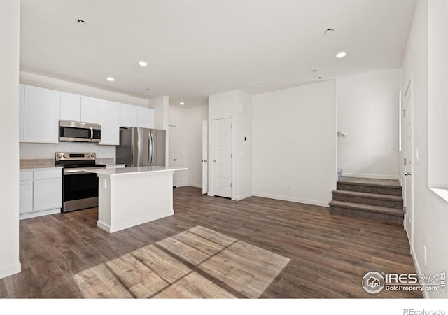 kitchen featuring white cabinetry, stainless steel appliances, dark wood finished floors, and open floor plan