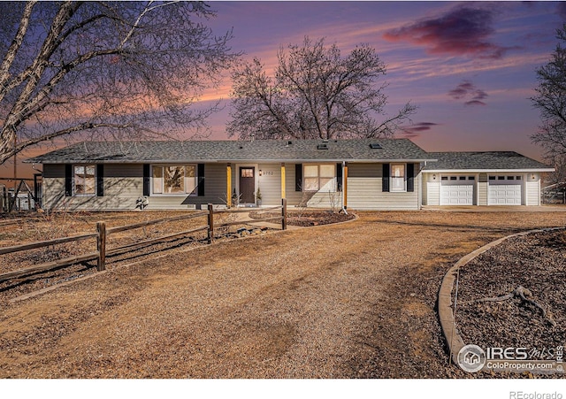 ranch-style house featuring driveway, a garage, and fence