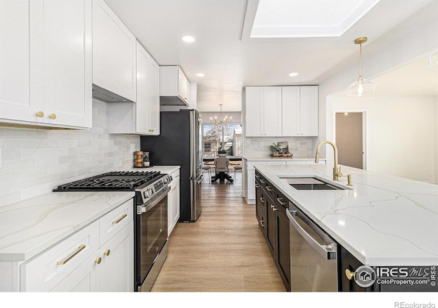 kitchen featuring stainless steel appliances, a sink, and white cabinetry