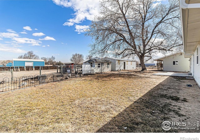 view of yard with fence and an outdoor structure