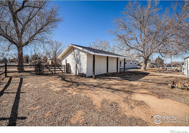 view of side of home with a gate and fence