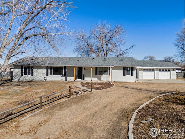 ranch-style house with a garage, driveway, and a fenced front yard