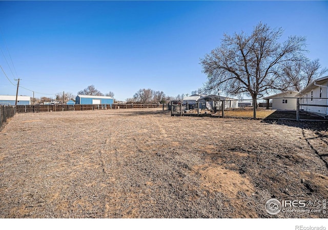 view of yard featuring an outbuilding and fence