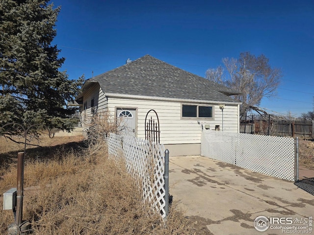 view of home's exterior with a patio area and fence