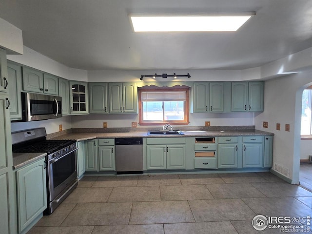 kitchen featuring green cabinets, stainless steel appliances, a sink, and visible vents