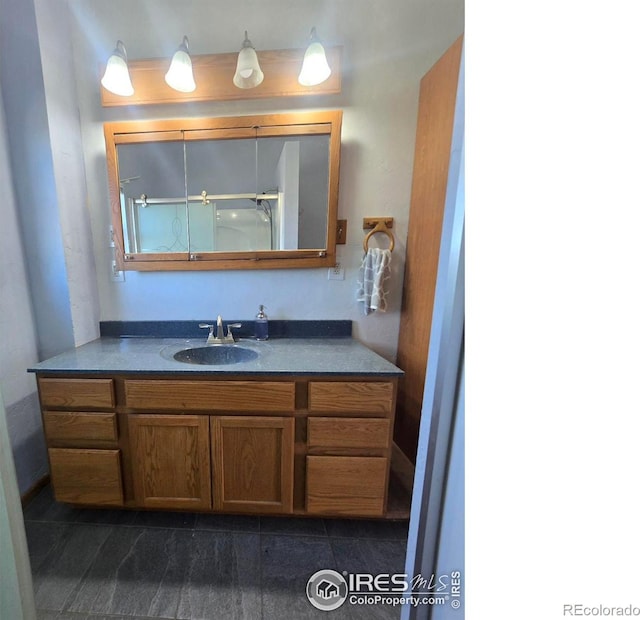 bathroom featuring walk in shower and vanity