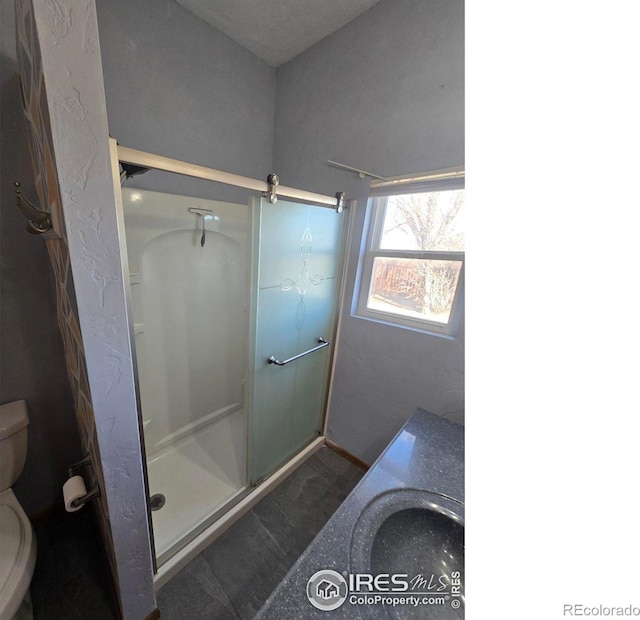 bathroom with a shower stall and toilet