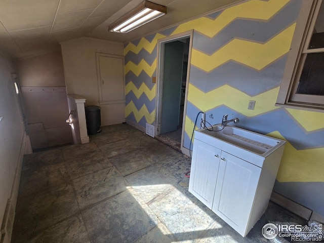 laundry area with a sink and wallpapered walls