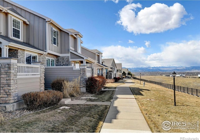 surrounding community with a residential view, fence, a mountain view, and a yard