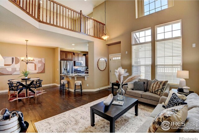 living area featuring a wealth of natural light, dark wood finished floors, and baseboards