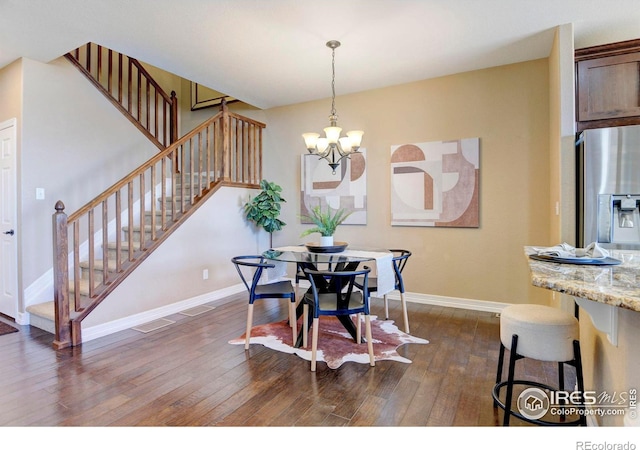 dining room with dark wood-style floors, a notable chandelier, baseboards, and stairs