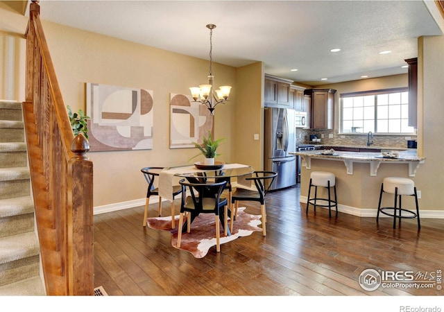 dining room featuring dark wood-type flooring, baseboards, and stairs