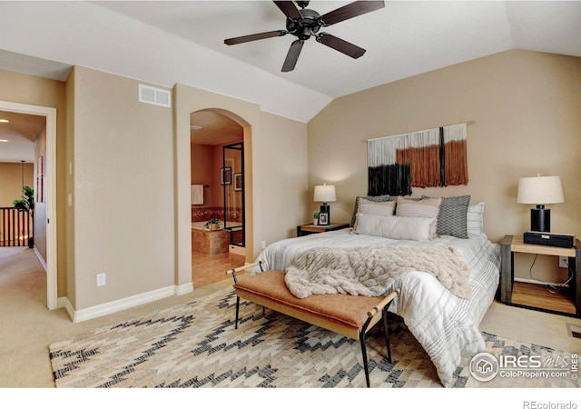 bedroom with arched walkways, visible vents, carpet flooring, vaulted ceiling, and baseboards