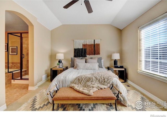 bedroom with arched walkways, vaulted ceiling, and baseboards