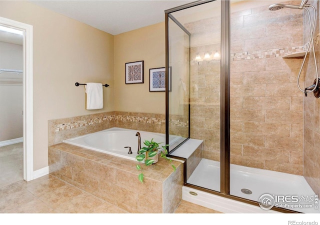 full bathroom with a stall shower, a bath, and tile patterned floors