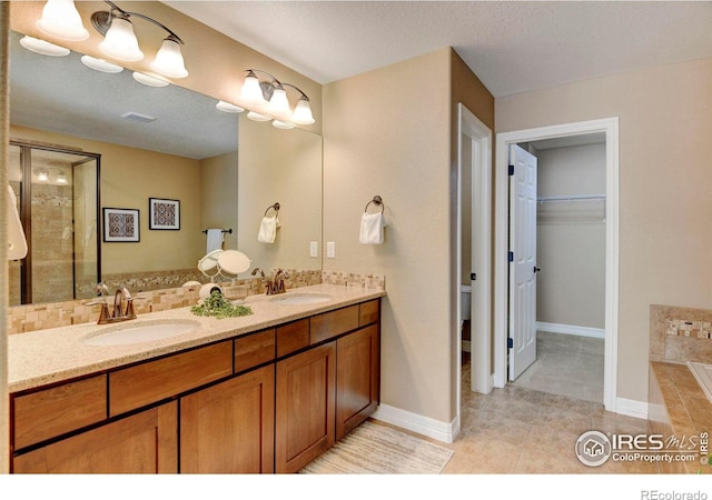 bathroom with tasteful backsplash, a garden tub, a sink, and double vanity