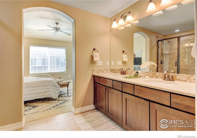 ensuite bathroom featuring double vanity, a stall shower, a sink, and tile patterned floors