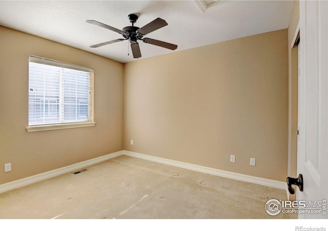 spare room featuring carpet floors, baseboards, visible vents, and a ceiling fan