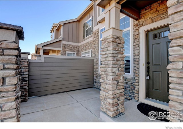 entrance to property with stone siding and board and batten siding