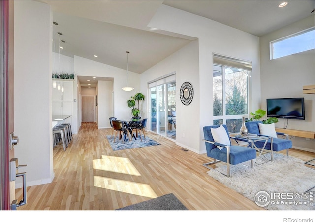 living room featuring baseboards, high vaulted ceiling, recessed lighting, and light wood-style floors