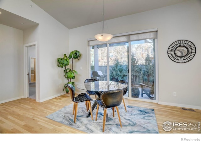 dining space featuring visible vents, baseboards, and wood finished floors