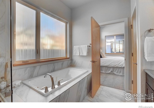 bathroom featuring a garden tub, marble finish floor, and ensuite bath