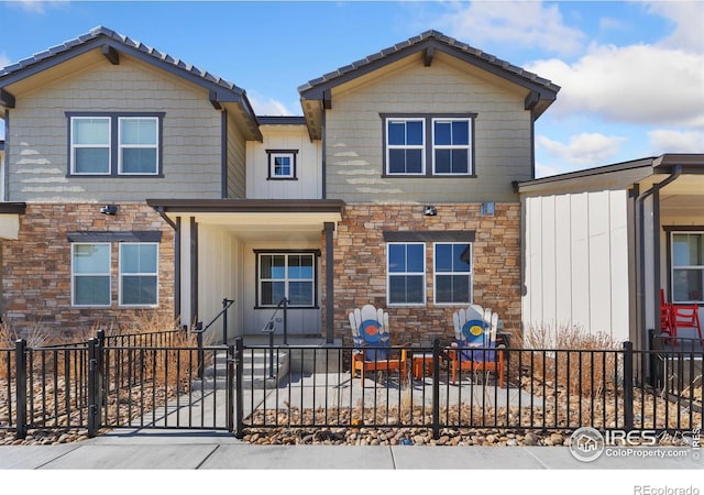 view of front of property with stone siding and a fenced front yard