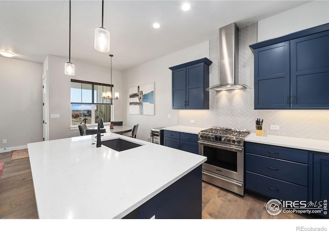 2748 Prairie Flax St, Berthoud, CO 80513 - kitchen with a sink, blue cabinetry, wall chimney exhaust hood, and high end stove
