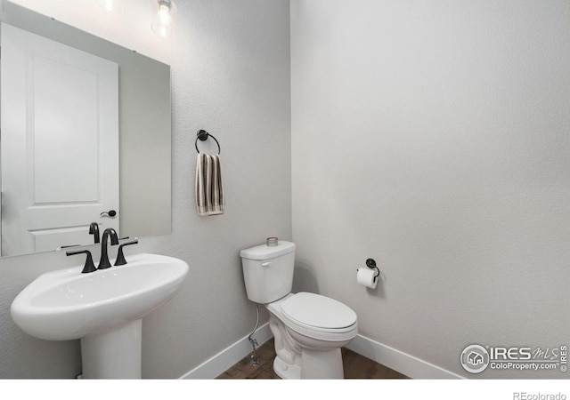 2748 Prairie Flax St, Berthoud, CO 80513 - bathroom featuring a sink, toilet, wood finished floors, and baseboards