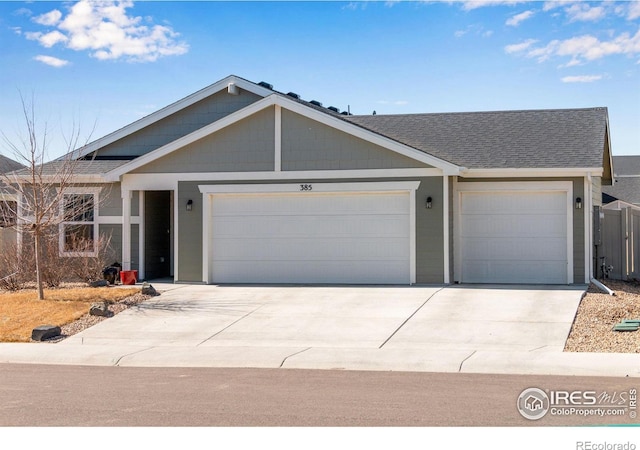 ranch-style home with a garage, concrete driveway, and a shingled roof