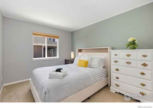 bedroom with light carpet and baseboards