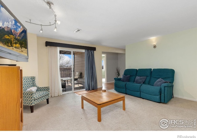 carpeted living area featuring track lighting, visible vents, and baseboards