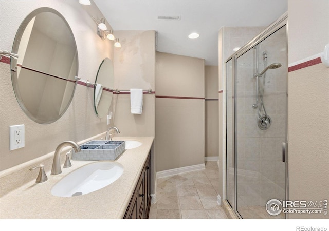 bathroom with double vanity, a sink, visible vents, and a shower stall