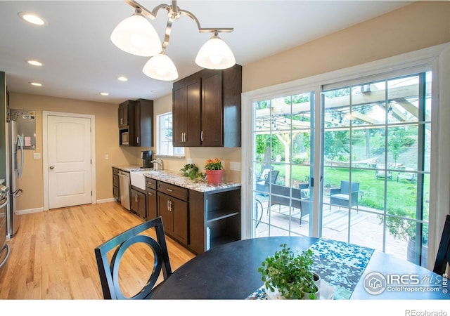 kitchen with light wood finished floors, recessed lighting, freestanding refrigerator, a sink, and dark brown cabinets