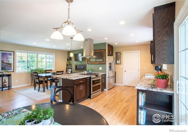 kitchen with dark brown cabinetry, light wood-style flooring, island range hood, and stainless steel appliances