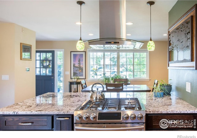 kitchen with a healthy amount of sunlight, island range hood, light stone counters, and stainless steel range with gas stovetop