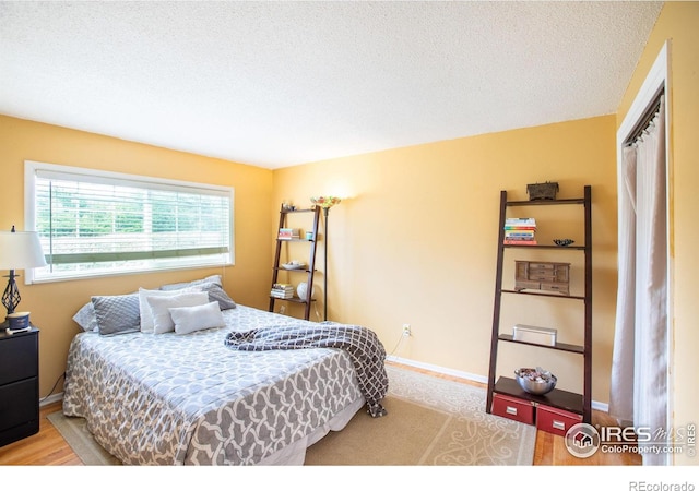 bedroom with baseboards and a textured ceiling