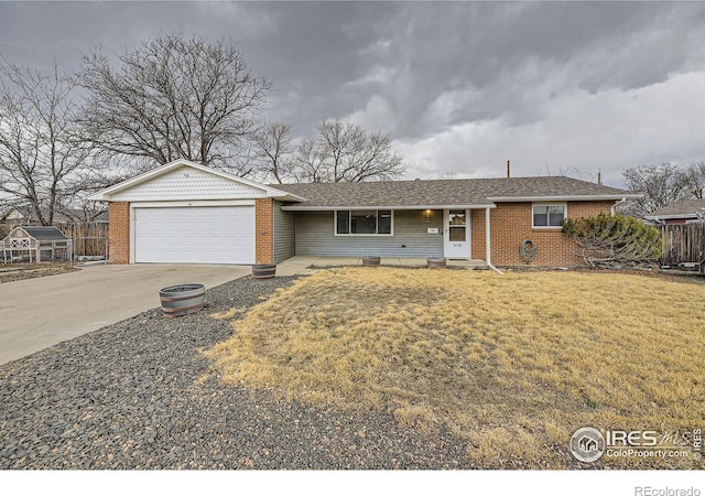 ranch-style house featuring an attached garage, brick siding, fence, driveway, and a front yard