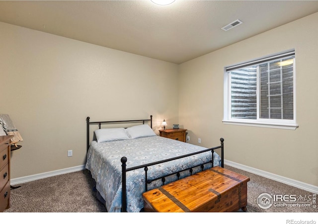 bedroom with carpet floors, visible vents, and baseboards