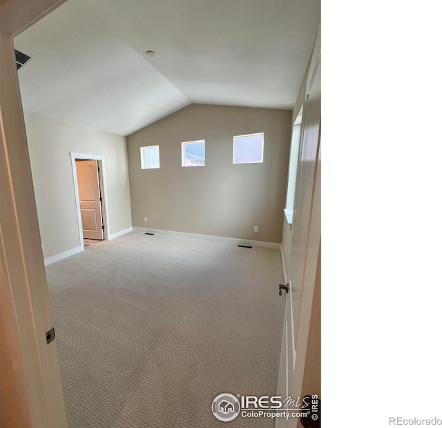 additional living space featuring carpet floors, baseboards, and vaulted ceiling