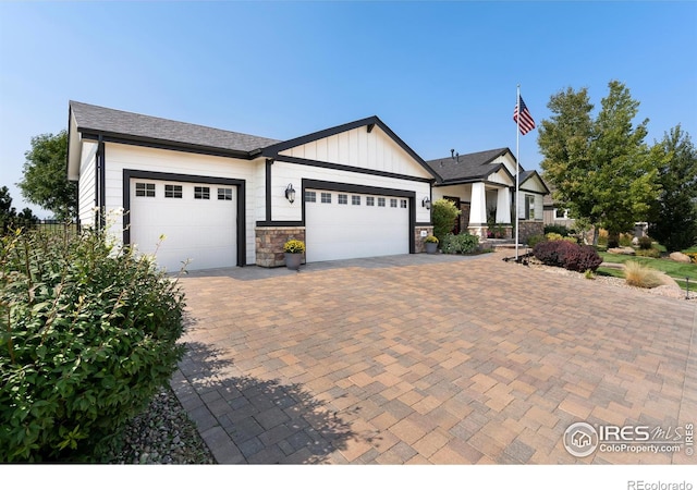 view of front of property with an attached garage, decorative driveway, and board and batten siding