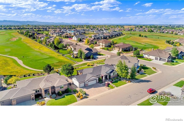 drone / aerial view with view of golf course and a residential view