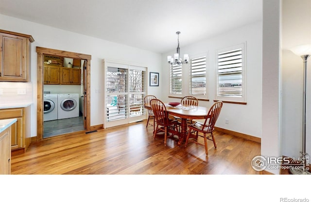 dining area with a notable chandelier, visible vents, light wood-style flooring, washer and dryer, and baseboards