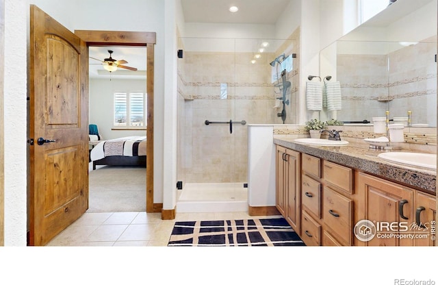 full bath featuring tile patterned flooring, a sink, a shower stall, and double vanity