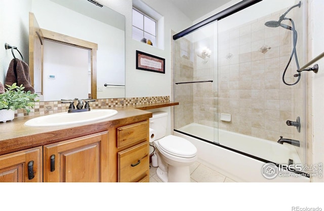 full bathroom featuring toilet, shower / bath combination with glass door, tile patterned flooring, and vanity