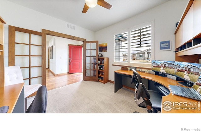 home office featuring baseboards, visible vents, a ceiling fan, light colored carpet, and french doors