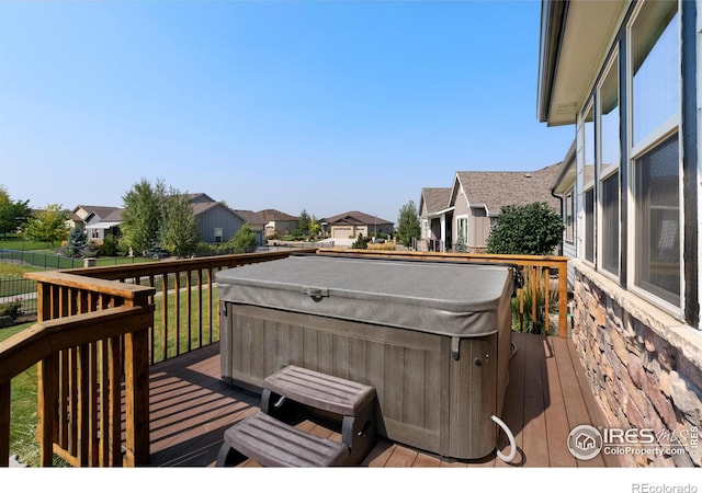 wooden terrace featuring a residential view and a hot tub