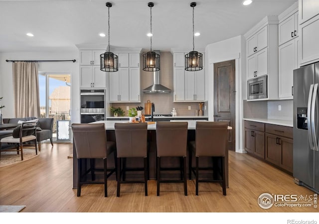 kitchen featuring stainless steel appliances, light countertops, and light wood finished floors