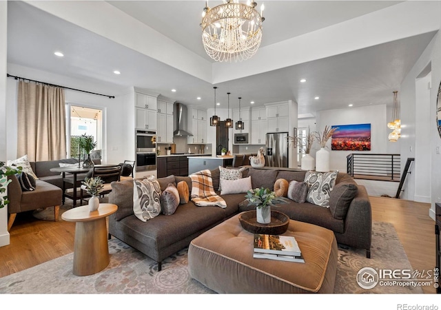 living area with light wood-type flooring, a notable chandelier, and recessed lighting